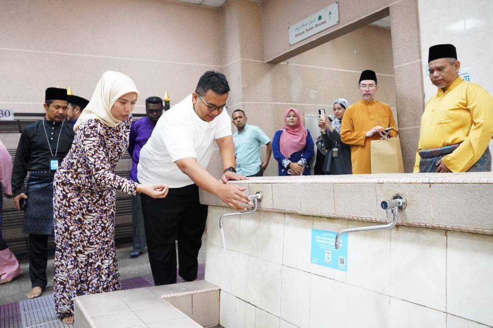 Ketua Pegawai Eksekutif Air Selangor, Adam Saffian Ghazali (dua dari kiri) ketika menghadiri satu program penggantian pili cekap air di masjid.