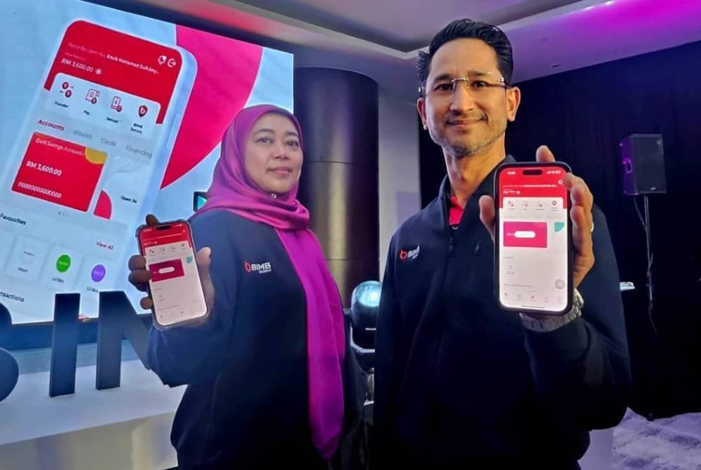 Mohammed Iran Moriff (kanan) bersama Ketua Saluran Maya Bank Islam,Nur Fathmawati Zakaria menunjukkan aplikasi perbankan mudah alih BIMB Mobile (BIMB Mobile).