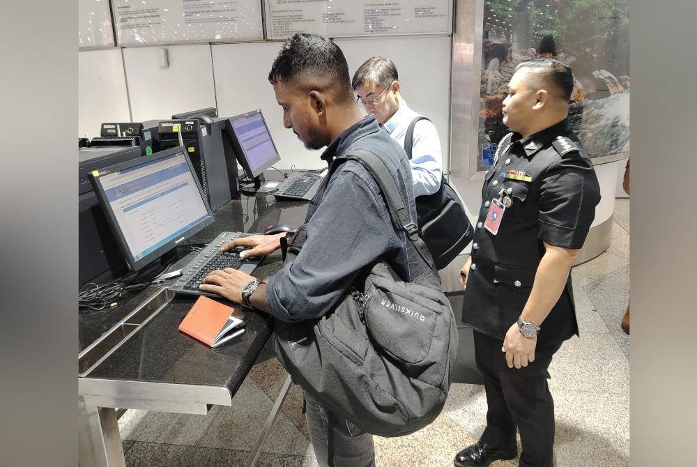 Pegawai Imigresen KLIA memantau pengisian borang dalam talian MDAC oleh warga asing yang tiba di Malaysia.