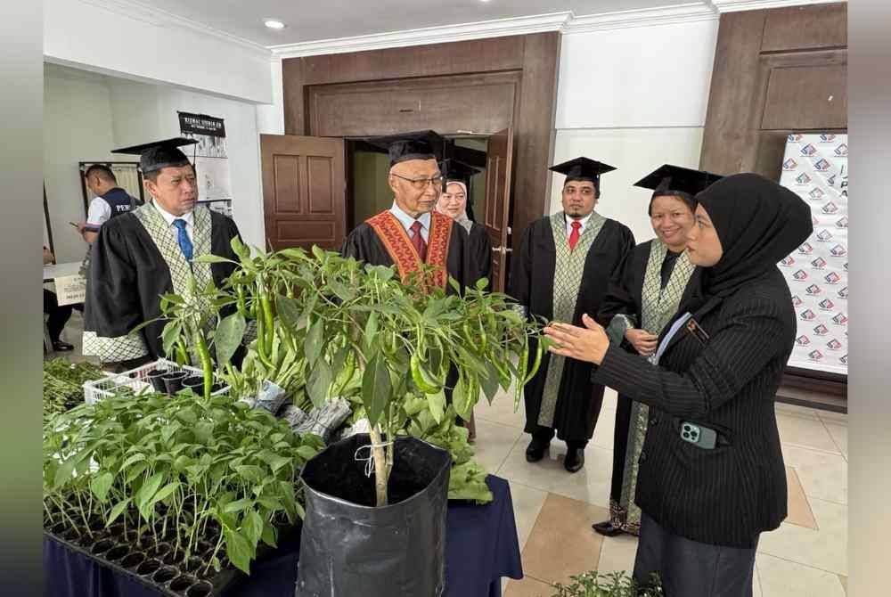 Dari kiri, Abdullah dan Ismail mendengar penerangan daripada seorang pelatih Perhebat yang berkecimpung dalam bidang pertanian sebagai bakal kerjaya keduanya.