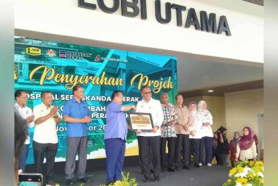 Dzulkefly (kanan) menerima cenderahati daripada Alexander selepas Majlis Penyerahan Projek Hospital Seri Iskandar dan Blok Tambahan HSM di HSI di sini, pada Khamis.