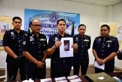 Syed Basri (tengah) menunjukkan gambar Siti Rohani yang diedarkan untuk membantu siasatan polis.