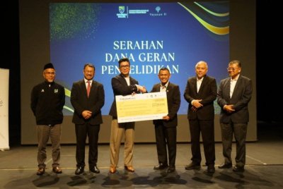 RIZALMAN (tiga dari kanan) menyerahkan replika cek dana geran penyelidikan berjumlah RM2.25 juta daripad Yayasan Rizalman Ibrahim kepada Kaharudin (tiga dari kanan). 