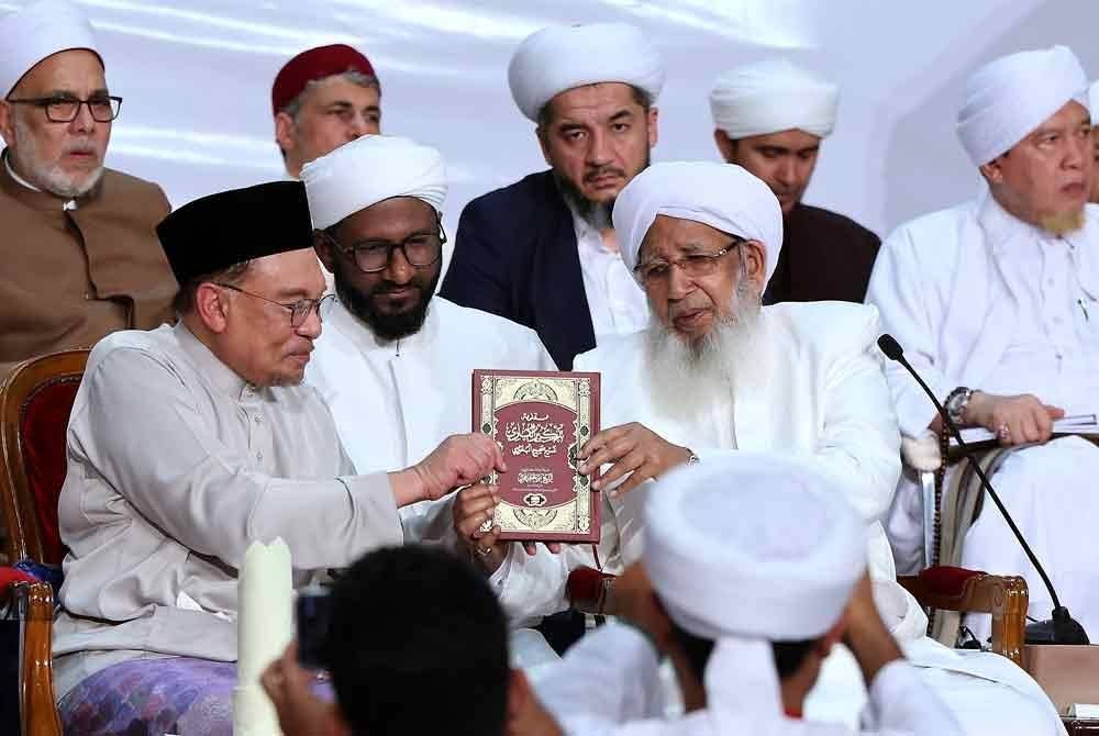 Perdana Menteri,Datuk Seri Anwar Ibrahim (kiri) menerima Kitab Sahih al-Bukhairi daripada Mufti Besar India Sheikh Abu Bakar Ahmad al-Malibari (kanan) pada Majlis Perasmian Penutup Majlis Sama' Hadis Sahih Al-Bukhairi Peringkat Kebangsaan 2024 di Masjid Putra malam ini. Foto Bernama