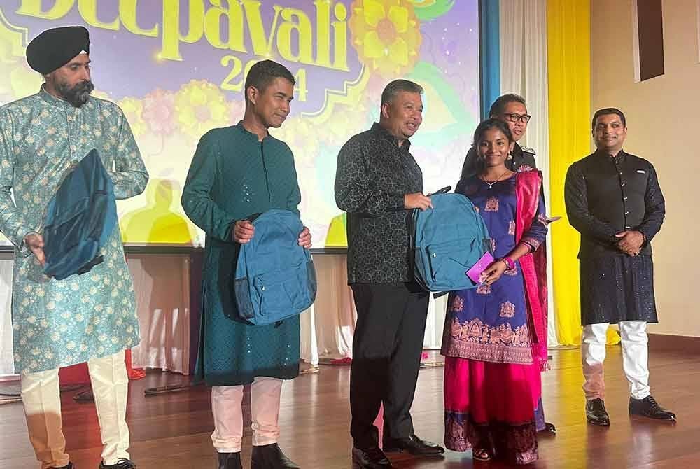 Zakaria (tengah) menyerahkan sumbangan ketika Majlis Sambutan Deepavali JIM Kuala Lumpur di Kompleks Kementerian Dalam Negeri (KDN), Kuala Lumpur pada Khamis.