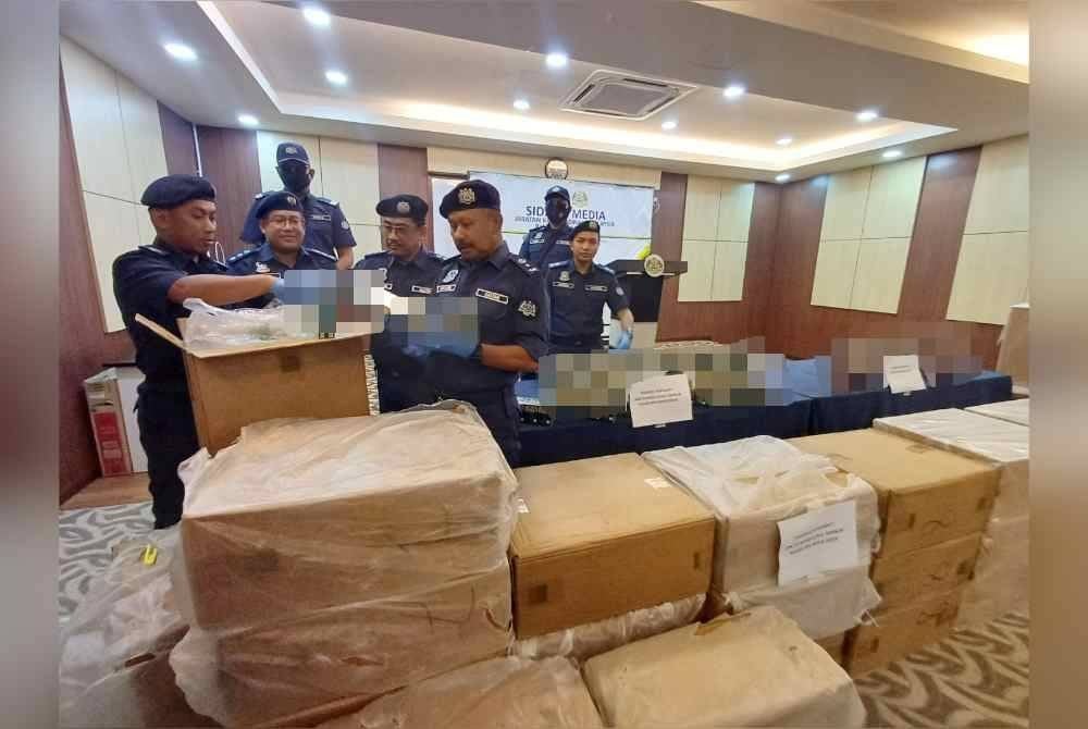 Mohd Asri (kanan) melihat pokok seludup yang dirampas dalam serbuan berasingan di Rompin dan Melaka.