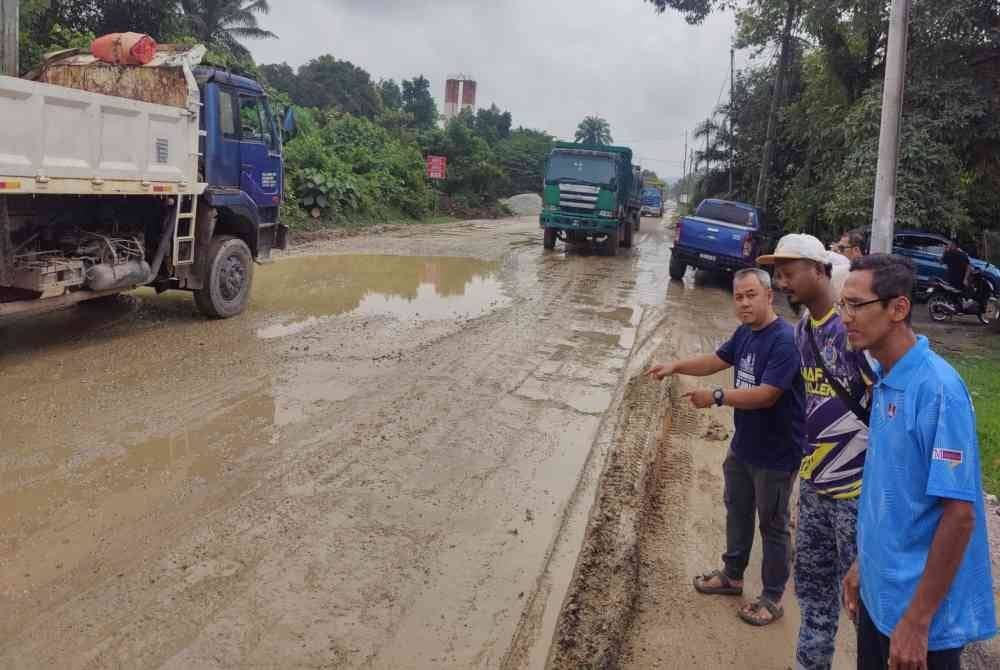 Sebahagian ibu bapa menunjukkan Jalan Pasar Malam di Kampung Bukit Kapar di sini yang mengalami kerosakan teruk sejak tiga bulan lalu.