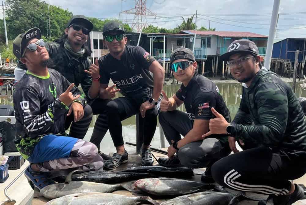 Mohd Khushairi bersama rakan-rakannya menunjukkan hasil tangkapan yang diperoleh mereka.