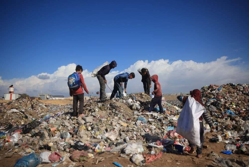 Beberapa remaja Palestin mengutip barangan yang boleh digunakan semula di sebuah tapak pelupusan sisa sampah.