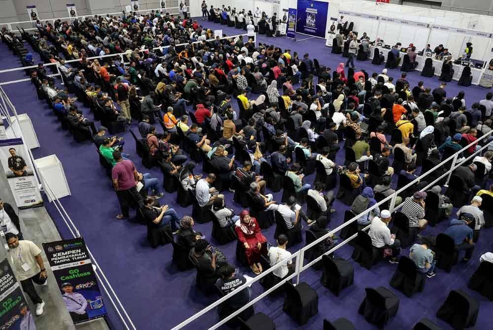 Orang ramai menyemak dan membayar saman trafik di kaunter khas bayaran kompaun saman Polis Diraja Malaysia (PDRM) sempena Program Dua Tahun Kerajaan MADANI (2TM) di Pusat Konvensyen Kuala Lumpur (KLCC). Foto Bernama