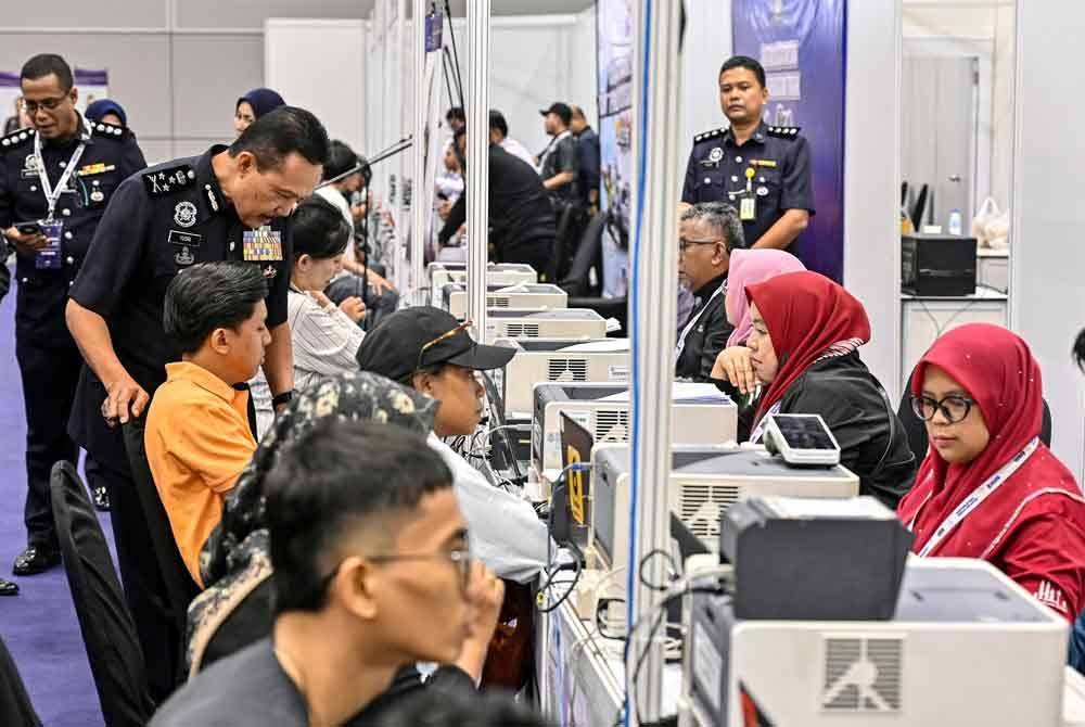 Mohd Yusri (dua dari kiri), beramah mesra bersama orang ramai yang menyemak dan membayar saman trafik di kaunter khas bayaran kompaun saman PDRM sempena Program Dua Tahun Kerajaan MADANI (2TM) di Pusat Konvensyen Kuala Lumpur (KLCC). Foto Bernama