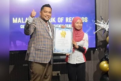 Dr Nazri Khan (kiri) menerima penghargaan daripada Ketua Penyelidikan Malaysia Book of Record, Siti Norhanim (kanan) sebagai anak Malaysia pertama dinobatkan Juara Trader Dunia 2024 & diiktiraf sebagai “Most World Cup Trading Championship Won In A Year 2024” oleh *The Malaysia Book of Records baru-baru ini.
