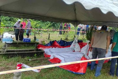 Penduduk kampung bergotong-royong mengalihkan jenazah selepas tanah perkuburan runtuh dalam kejadian hakisan di Kampung Pengkalan Maras, Kuala Nerus