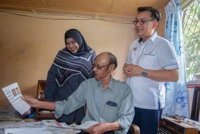 Timbalan Ketua Setiausaha (Komunikasi Strategik dan Industri Kreatif) Kementerian Komunikasi, Nik Kamaruzaman Nik Husin (kanan) melihat keratan akhbar yang dihasilkan wartawan veteran akhbar Daily Express, Sohan Das, 81, (tengah) pada Program Ziarah Kasih dan Penyerahan Bantuan Tabung Kasih@HAWANA di kediaman Sohan pada Sabtu. Foto Bernama