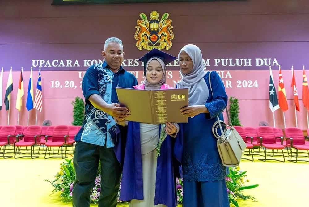 Nor Elisha bersama kedua ibu bapanya bergambar kenangan selepas sempena Upacara Konvokesyen ke-62 Universiti Sains Malaysia (USM) pada Ahad.