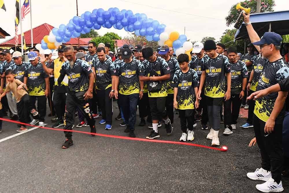 Mohd Jamil (kanan) bergambar bersama penduduk sebelum melepaskan para peserta 'Fun Run' sejauh tiga kilometer pada Program Santuni Madani 'Satu Kampung, Satu Pemimpin' di Kampung Rapat Jaya hari ini. - Foto: Bernama