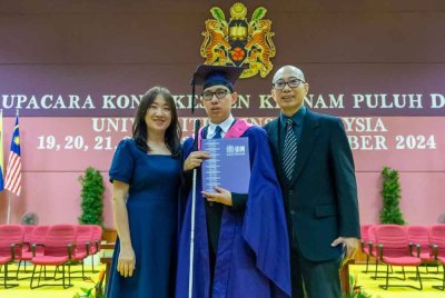 Zeng Fang bersama ibu bapanya, Alvin Teoh dan Goh Bee Hiang bergambar kenangan selepas menerima ijazah sempena Upacara Konvokesyen ke-62 Universiti Sains Malaysia (USM) pada Ahad.