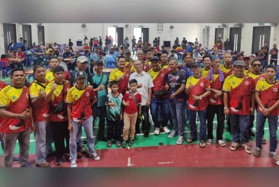 Harrison (tengah) bergambar bersama-sama urusetia dan peserta Kejohanan Karom Beregu Terbuka Piala ADUN Jeram di Dewan Masjid Ae Ridhuan, Pekan Jeram pada Ahad.
