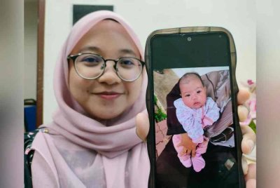 Nur Halimatussa'diyah menunjukkan Alia Majidah yang ditinggalkan dalam peti pelindung bayi di Orphan Care Foundation.