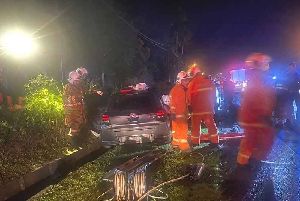 Anggota keselamatan mengeluarkan mangsa yang tersepit di tempat duduk kenderaan.
