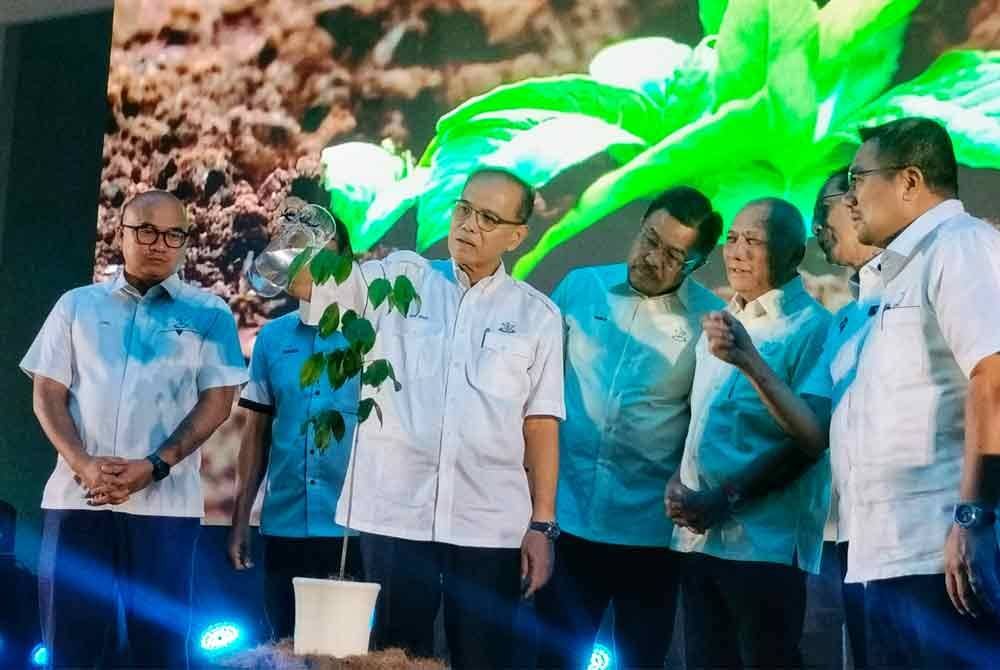Wan Rosdy (tiga dari kiri) menyiram pokok sebagai simbolik perasmian Hari Hutan Antarabangsa Peringkat Negeri Pahang di Dewan UiTM Cawangan Pahang Kampus Raub pada Isnin.