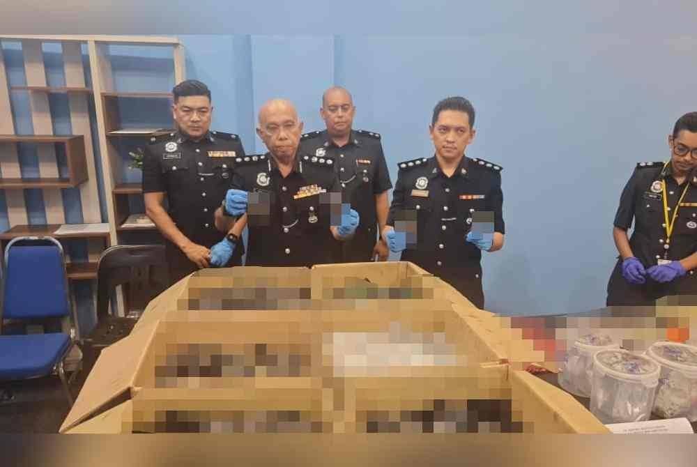 Ahmad Sukarno (dua kiri) menunjukkan dadah yang dirampas.