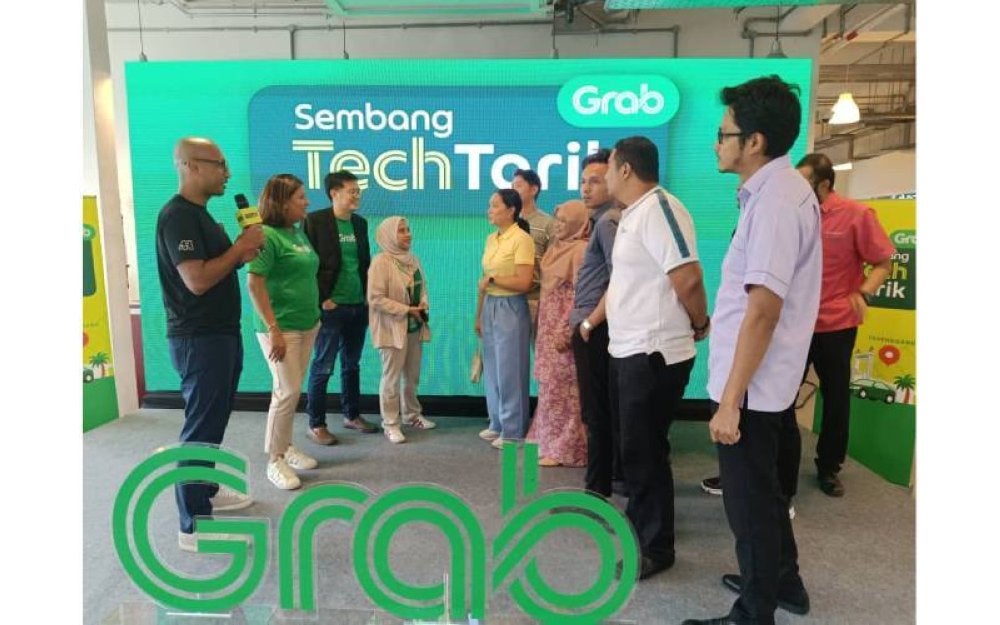 Rashid (kiri) berkongsi tentang ilmu dan pandangan bersama Rakan Grab di Terengganu.
