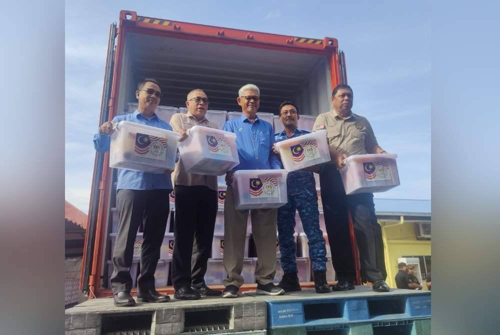 Aminuddin (tengah) menunjukkan kit makanan yang dimasukkan ke dalam kontena pada Majlis Pelepasan Pengedaran Kit Bantuan Makanan Bencana Negara Monsun Timur Laut di Pusat Memproses Makanan FAMA, Tanjong Karang di Kuala Selangor pada Selasa.