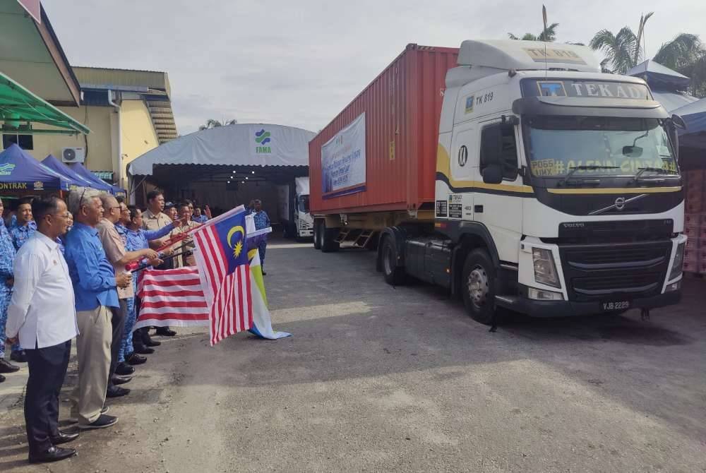 Aminuddin (dua dari kiri) membuat pelepasan pengedaran kit bantuan makanan itu di Pusat Memproses Makanan FAMA, Tanjong Karang.