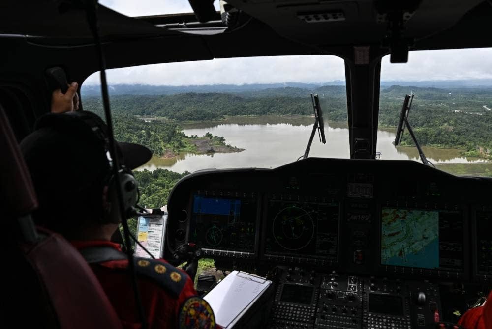 Anggota Unit Udara Jabatan Bomba dan Penyelamat Malaysia melakukan tinjauan keadaan banjir yang melanda negeri ini di sini hari ini. Foto Bernama
