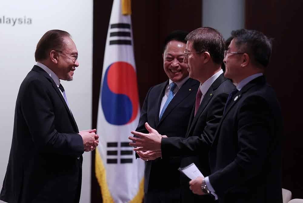 Anwar (kiri) mengadakan pertemuan dengan Samsung sempena lawatan rasmi beliau ke Korea Selatan pada Selasa. Foto Bernama