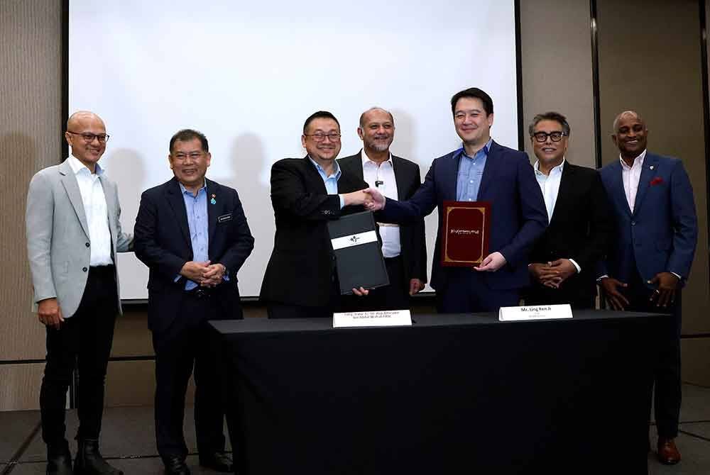 Gobind (belakang, tengah) menyaksikan majlis menandatangani perjanjian kerjasama dan pertukaran dokumen perjanjian di antara CyberSecurity Malaysia dan MyORI Services pada Selasa. Foto Bernama