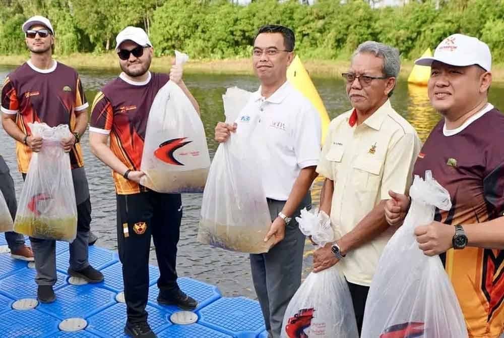 Tengku Amir (tiga dari kiri) diiringi Saipolyazan (tiga dari kanan) dan Rizam (kanan) bergambar sebelum pelepasan anak ikan semasa Karnival Ban Canal di Parit 14, Simpang Lima pada Selasa.
.