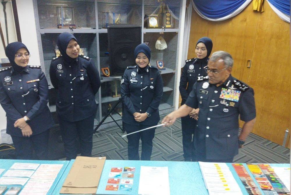 Ramli (kanan) menunjukkan barangan along yang dirampas.