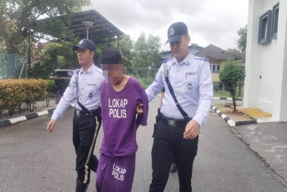 Suspek (tengah) diiringi polis ketika berada di pekarangan Mahkamah Majistret Besut.