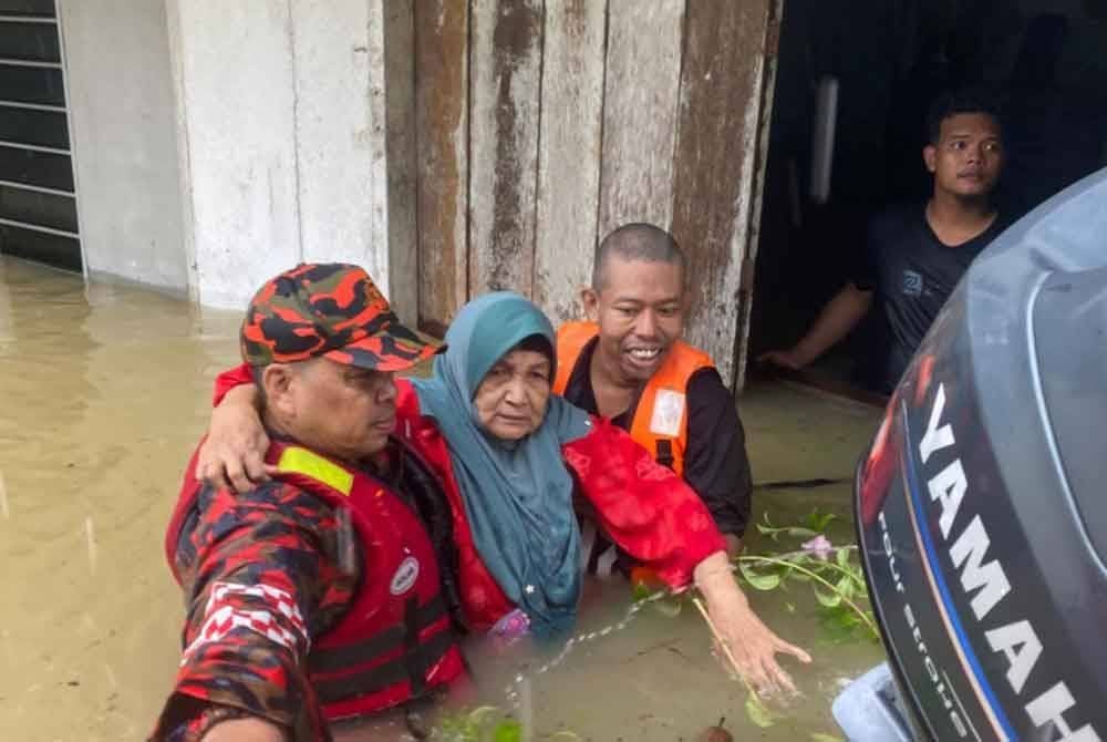Anggota JBPM menyelamatkan mangsa banjir di Kampung Kubang Kual, Rantau Panjang. Foto JBPM
