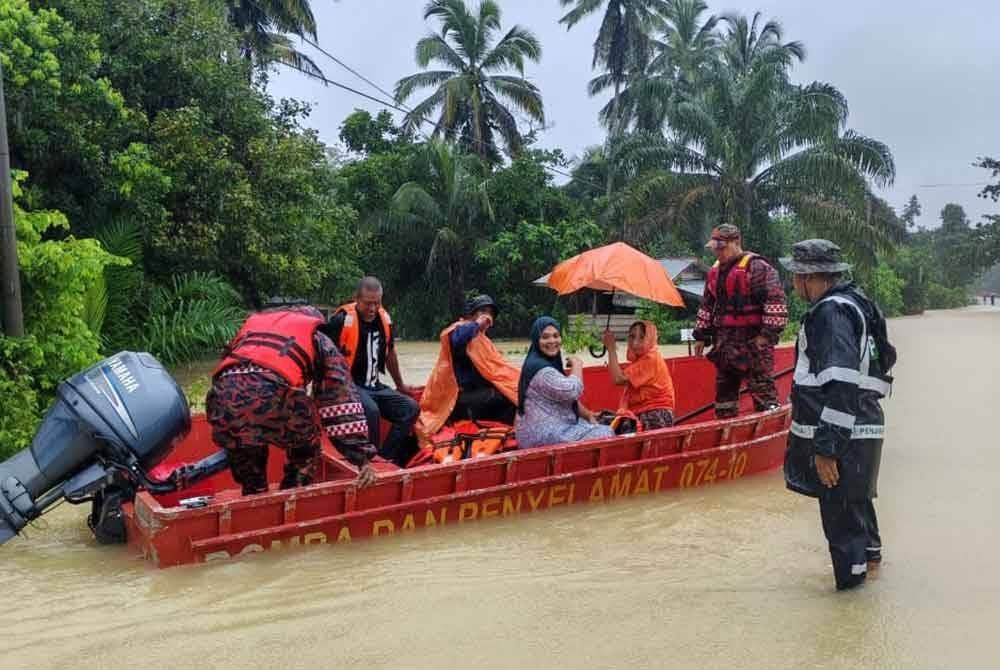 Pasukan penyelamat bertungkus-lumus menyelamatkan mangsa banjir. Foto JBPM