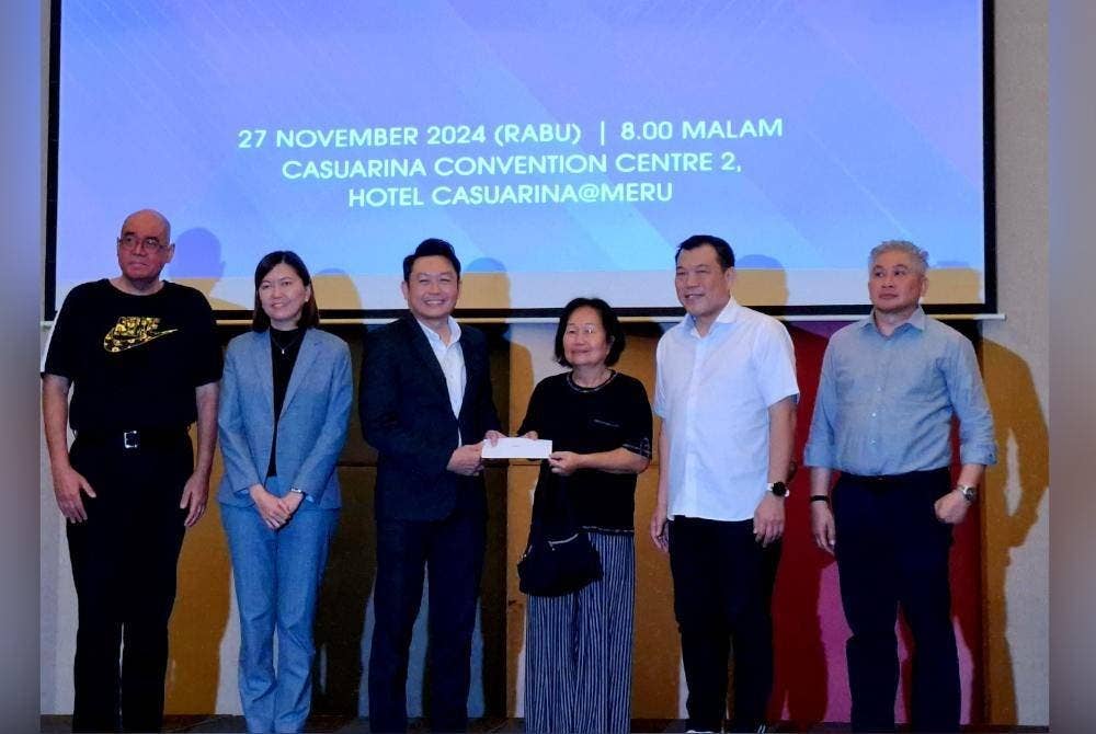 Chee Keong menyerahkan bayaran ex gratia kepada seorang petani setinggan.