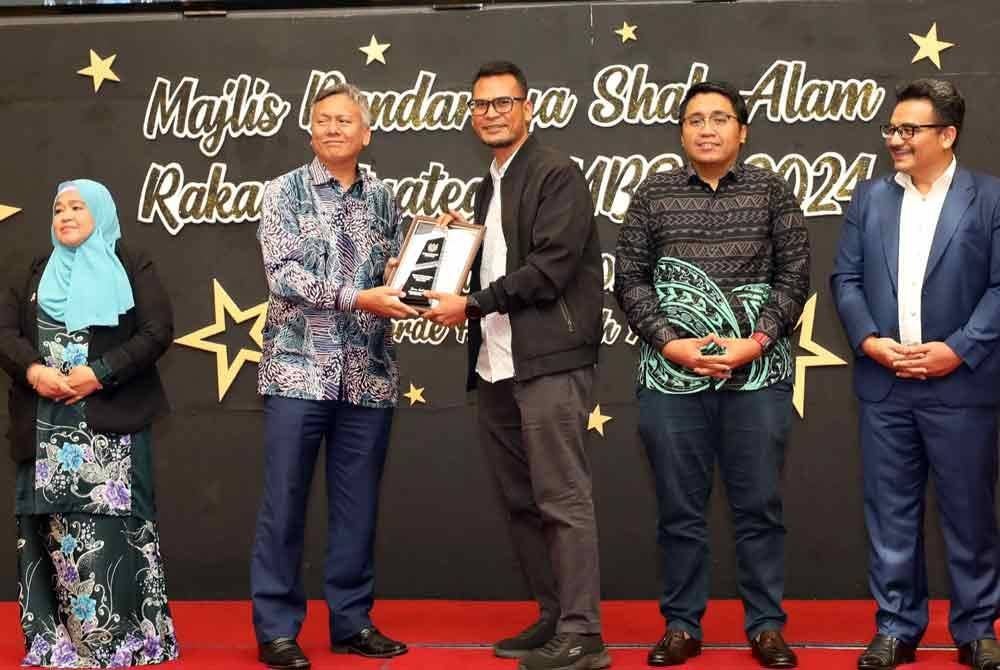 Timbalan Pengarang Berita, Badruldin Zakaria (tiga dari kanan) yang mewakili Sinar Harian menerima plak penghargaan daripada Madiyan (dua dari kiri).