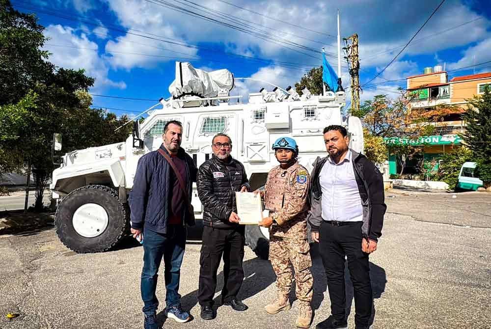 Khairil Annuar Khalid (dua dari kiri) memberi bungkusan makanan kepada salah seorang pegawai Malbatt di Beirut, Lubnan.