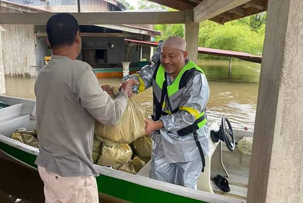 Mohd Nassuruddin (kanan) menghulurkan bantuan kepada mangsa banjir. Foto Facebook Mohd Nassuruddin