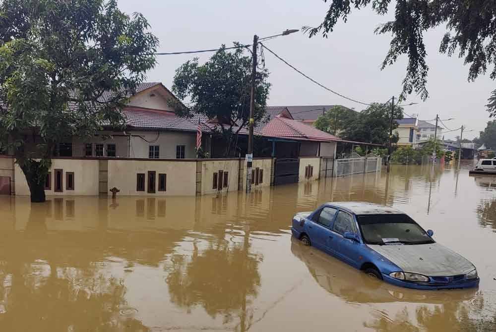 Sebuah kereta tersadai ditenggelami banjir di Taman Seri Puteri, Meru.