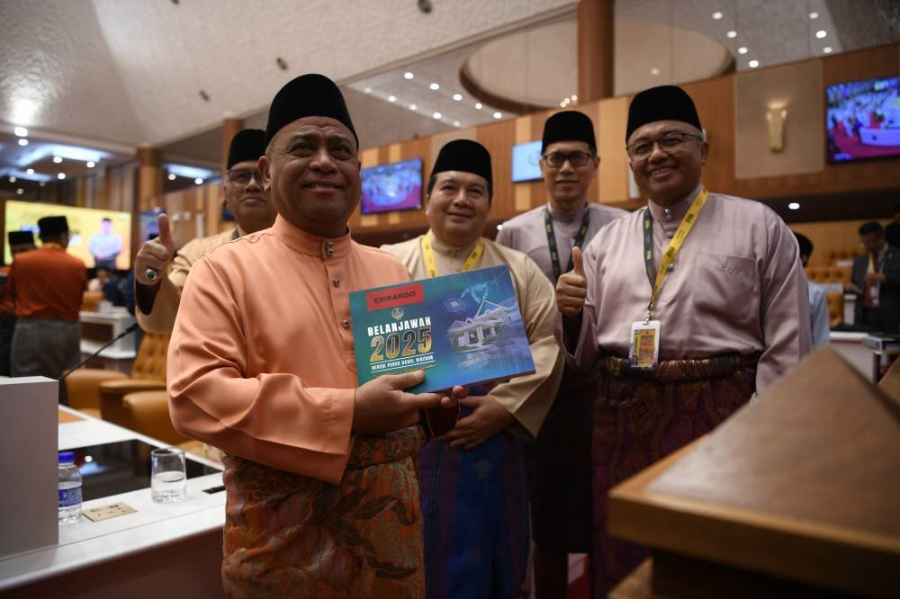 Saarani (kiri) menunjukkan buku Belanjawan Negeri Perak 2025 yang dibentangkan sempena Mesyuarat Ketiga Tahun Kedua Dewan Negeri Perak di sini pada Jumaat.