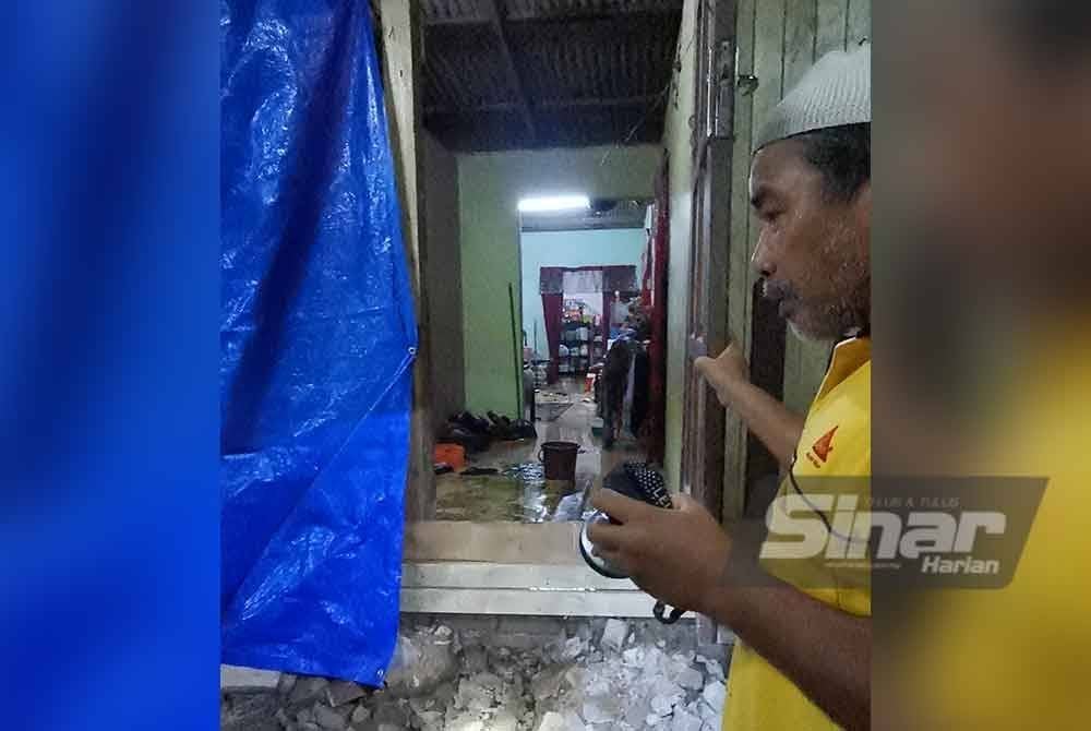Mohd Fauzi menunjukkan bahagian rumahnya di Kampung Baru Ajil yang dimasuki air.