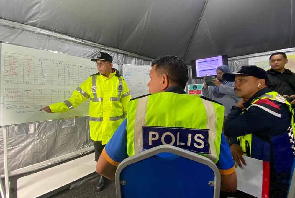 Mohd Yusoff (kanan) mendengar taklimat yang disampaikan oleh Ketua Polis Daerah Pasir Mas, Asisten Komisioner Kama Azural Mohamed semasa lawatan ke Balai Polis Repek, Pasir Mas pada Sabtu.