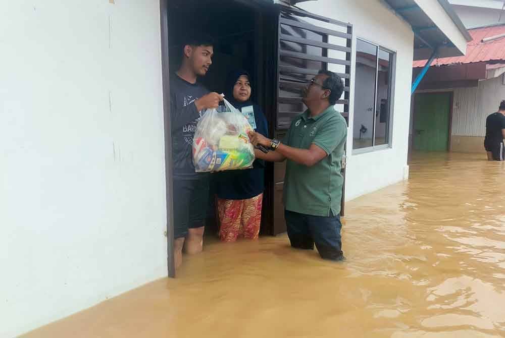Aripiah menerima sumbangan barangan keperluan daripada Persatuan Anak Muda Madani yang disampaikan Zuraidi pada petang Jumaat.