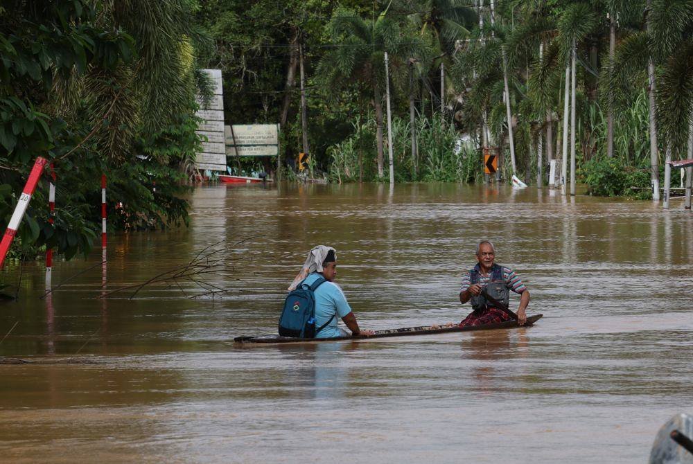 Mangsa banjir mendayung sampan untuk ke Pusat Pemindahan Sementara (PPS) Sekolah Menengah Kebangsaan Matang di Kampung Matang, hari ini. Foto Bernama