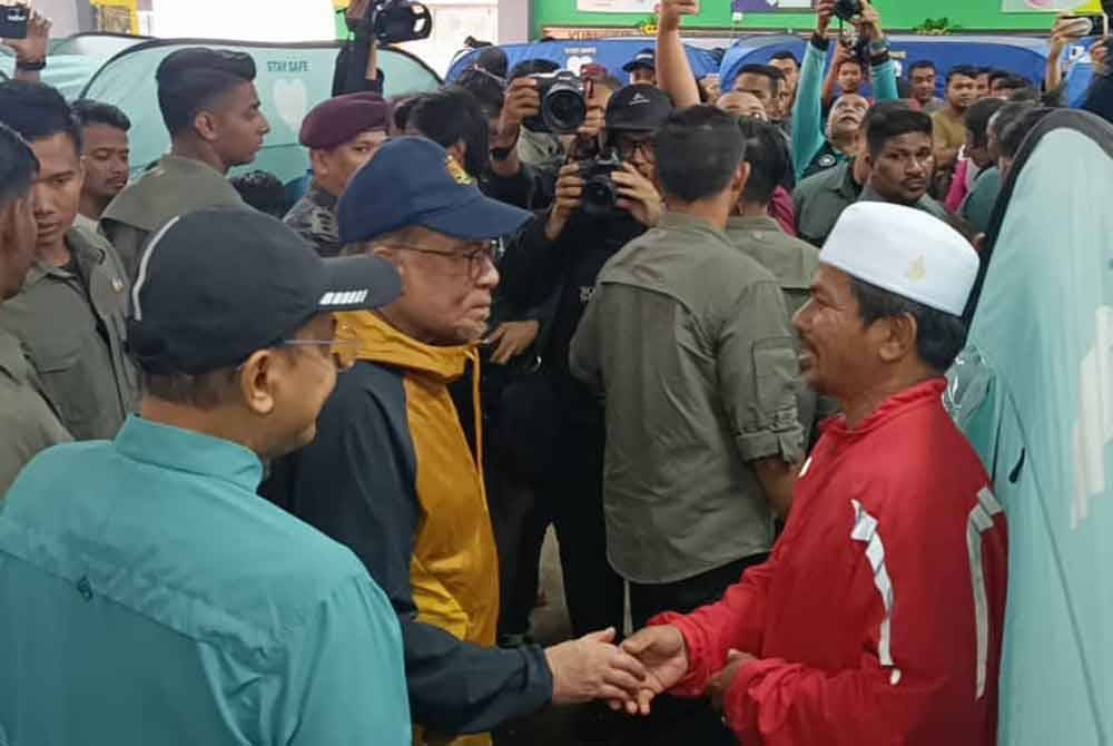 Anwar menyantuni mangsa banjir di PPS SK Telaga Papan.
