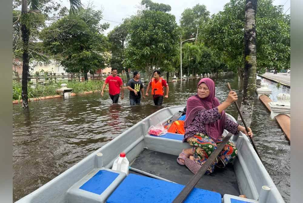 Mariam mendayung bot di kawasan banjir.