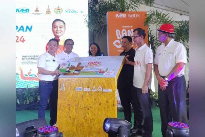 Suee Lim (kiri) menandatangani plak perasmian semasa Majlis Perasmian Penutupan Karnival Ban Canal 2024 di Parit 14, Simpang Lima di sini pada Ahad.